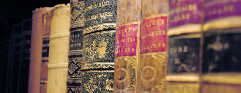 Nine colourful books arranged in an order (side view)