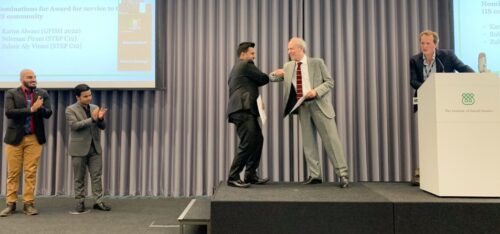 A GPISH student receiving student recognition award from Dr. Farhad Daftary