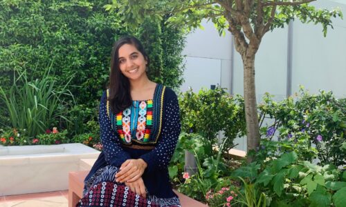 Anum Ameen Hossain sitting in a garden at AKC and posing for a picture