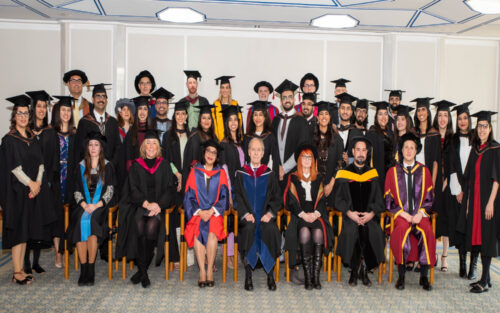 Cohort 12 graduates taking a group photo with the faculties and dignitaries all dressed in graduation gowns on the convocation day