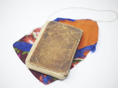 A book from the IIS archive placed over a colourful piece of cloth