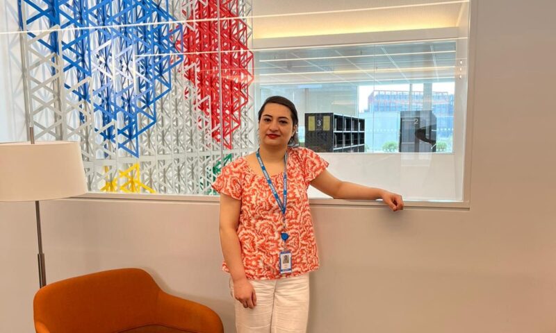 Dr Karen Bauer and Dr Feras Hamza leaning from the side with their opposite arms on the table with a printed copy of their book in the centre and posing