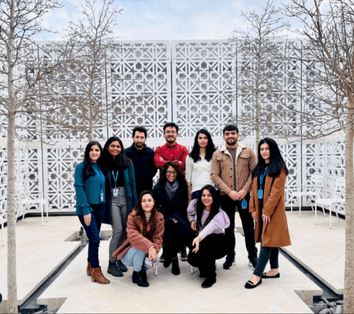 STEP C14 students standing in a group with Farah Manji (IIS faculty) in the centre posing for a picture in the terrace of Aga Khan Centre (AKC)