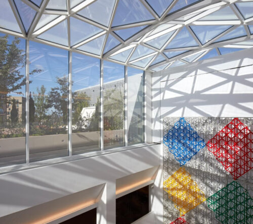 A generic image taken from inside of Aga Khan Centre 9th floor with a side view of one of the gardens and sunlight reflection from the ceiling.