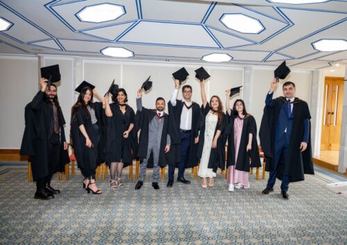 GPISH 2023 graduates wearing graduation gowns and throwing caps in the air