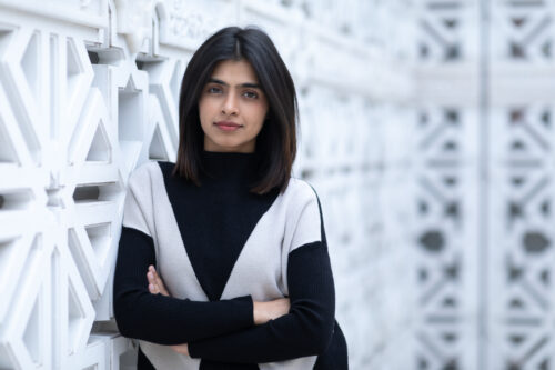 A student in black and grey dress posing for a photoshoot
