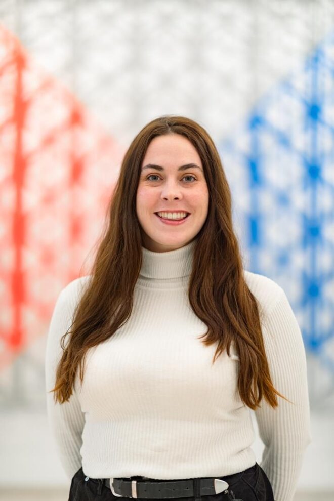 A woman in an off white shirt posing for a photo
