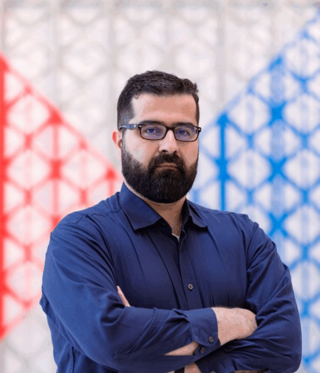 Hasan Al-Khoee in a blue shirt posing for a photo