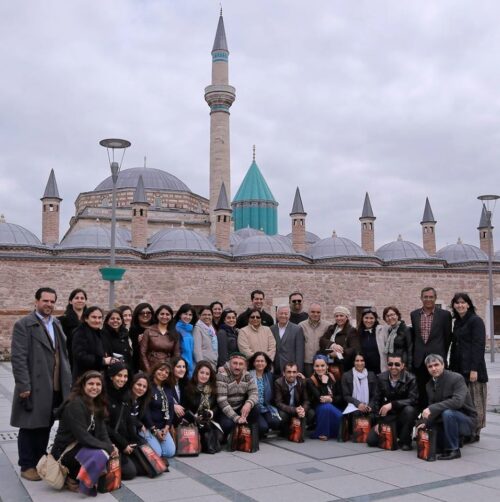 A group of people posing for a photo with an architectural monument in the background