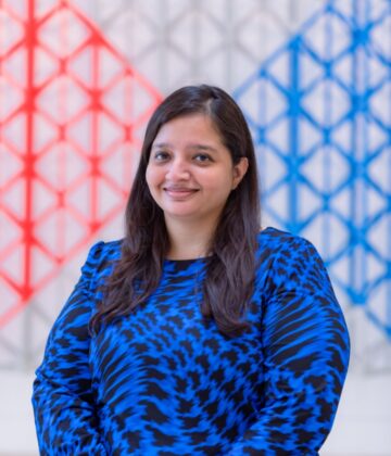 Naureen Ali in a blue dress posing for a photo