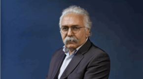 Prof. Mohammad A. Amir Moezzi in a black suit posing for a photo