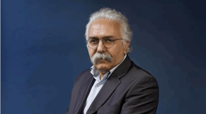 Prof. Mohammad A. Amir Moezzi in a black suit posing for a photo