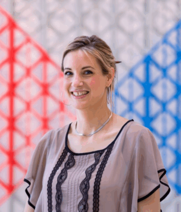 Rosa Barugh in a black-laced grey shirt posing for a photo