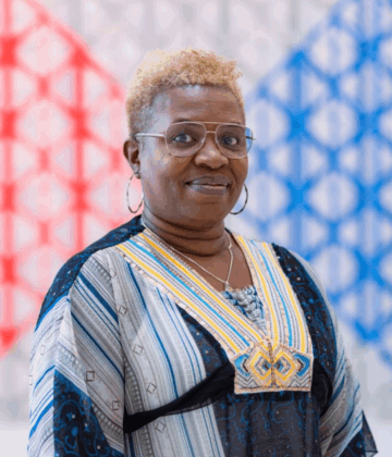 Shola Ajilore posing for a photo in the AKC background